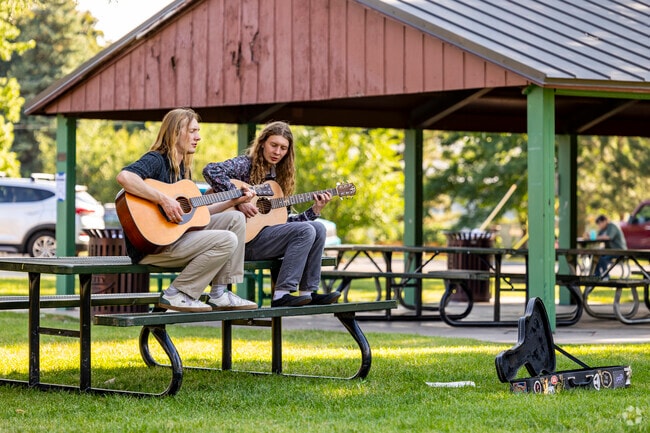 Two friends play their guitars at Main Street Park in downtown Heber.