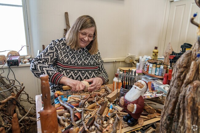 A wood sculptor carves a rabbit at the Village Artisans Gallery in Boiling Springs.