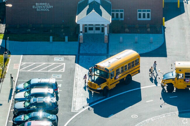Teachers walk students to the buses at Mabelle M. Burrell Elementary School in Foxborough, MA.