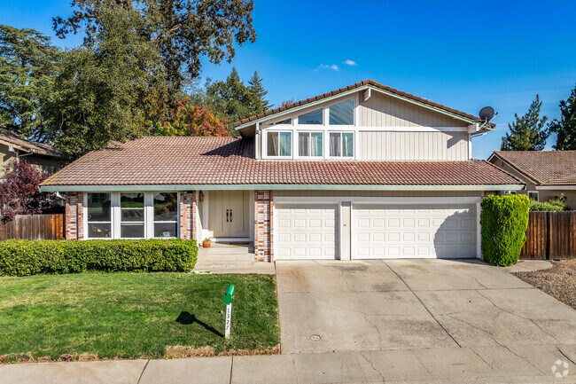 This 2-story home in Cirby Ranch has a tile roof with brick accents.