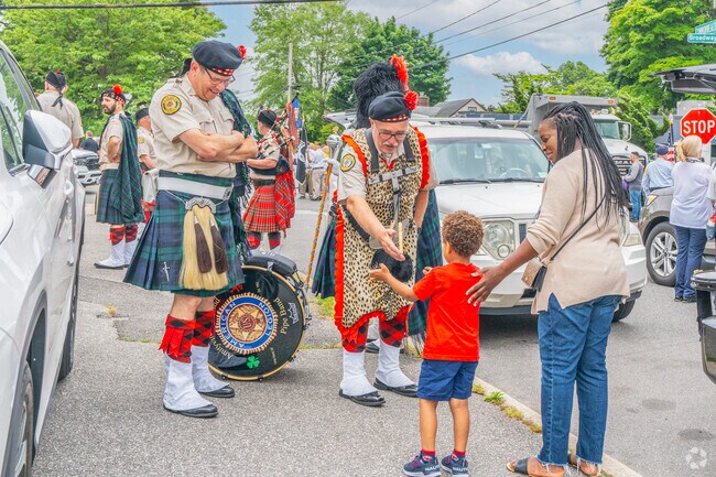 A Massapequa boy hands his toy to one of the marching band members from The American Legion.