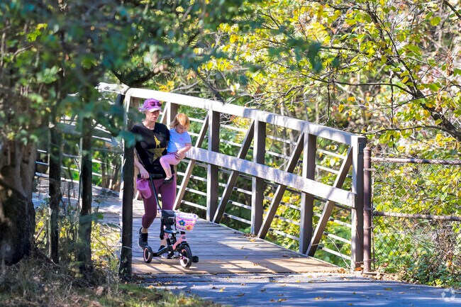 A mother and daughter stroll through Fairview Park, enjoying the shaded paths.