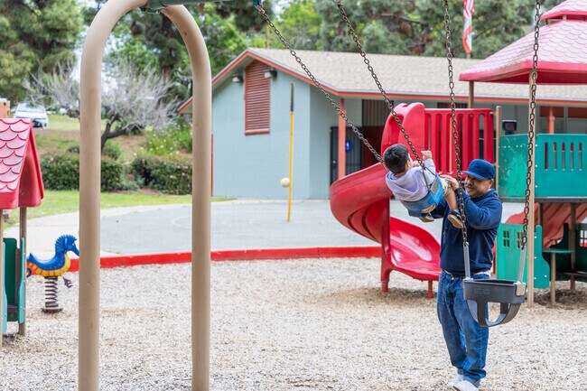 A man pushes his son on the swings in Azalea Community Park in Swan Canyon.