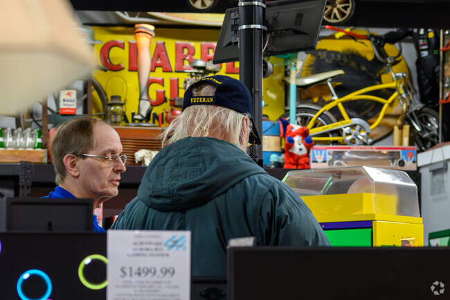 A helpful employee at Dicker & Deal Second Hand Store helps at shopper in Greencroft Park.