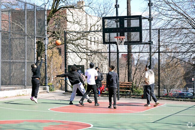 Morris Heights residents enjoying Sedgwick playground on sunny day.
