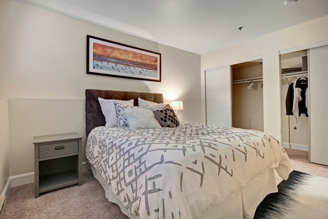 Bedroom with bed, night stands, and large closets with sliding doors