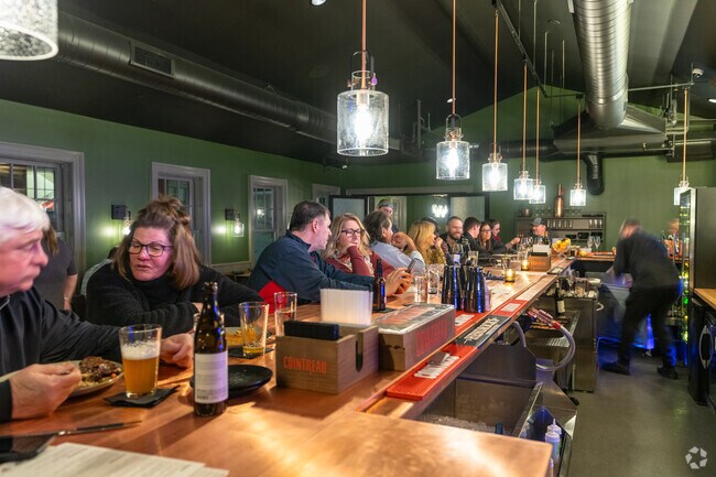 Folks drink craft beers and specialty wines at Unwined near Brookline.