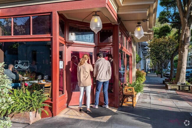 A couple stands in the entry of L’Ardoise Bistro, a French restaurant in Duboce Triangle.