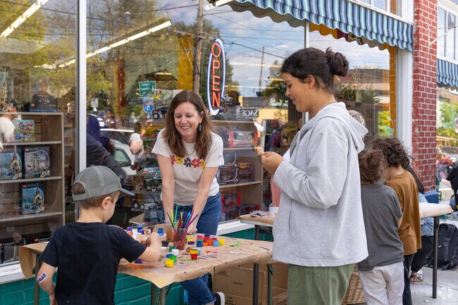 Enpire youngsters while they paint a tiny planter outside Thinker Toy Store.