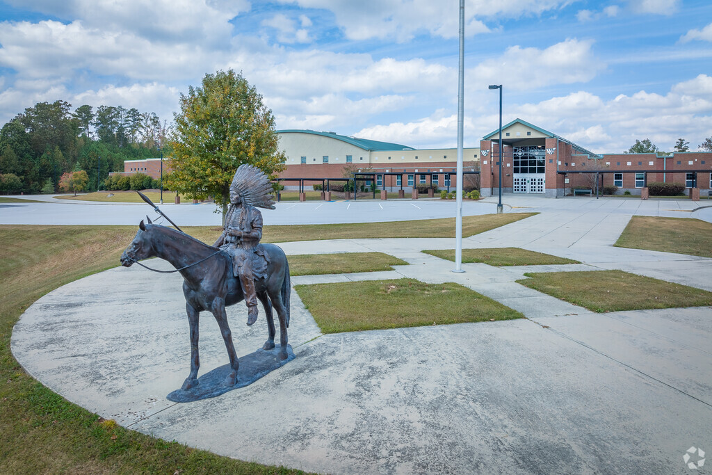 Wide shot of the school statue in front of the school