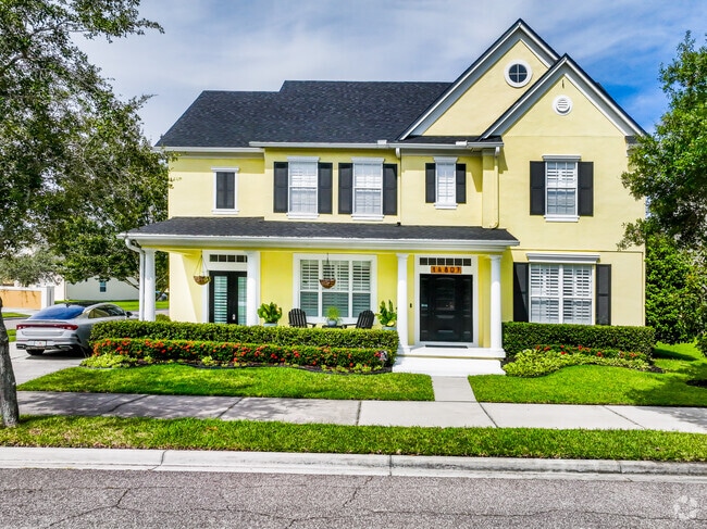 Bright-yellow, American Colonial home in a affluent neighborhood of Avalon Park.