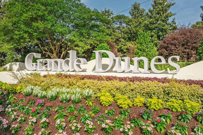 Grande Dunes welcomes residents with lush landscaping and a signature entrance sign.