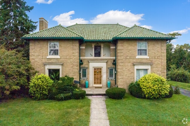 A masonry and buff brick Mediterranean home sits on a corner lot in Oakman Boulevard Community.