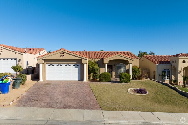The contemporary house in Edison features Spanish tiled roofing and distinct white pillars.