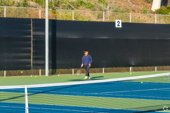 A boy plays tennis with friends at Colina Del Sol Recreation Center near Chollas Creek.