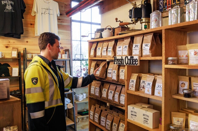 A man browses the ground coffee selection at Spill The Tea Cafe in Minoa.