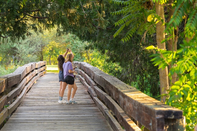 Good friends stop to take pictures along the bridge in Oakhurst Community Park.