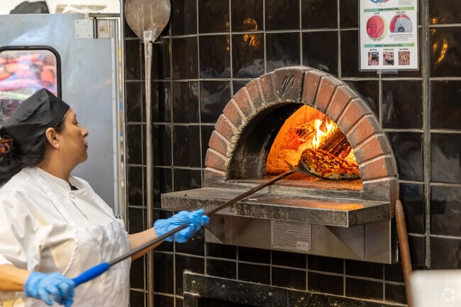 Lunch-goers enjoy wood-fired pizza at Smashing Tomato in Liberty Area.