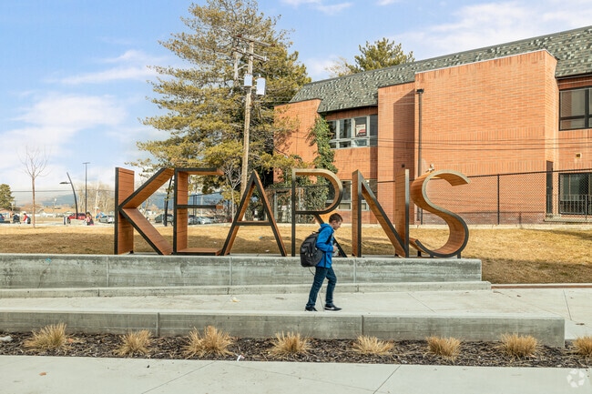 A teenage boy walks by an artistic sign at Kearns Library.