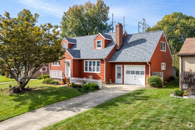 Colorful cape cod in Kirkmere features an attached garage.