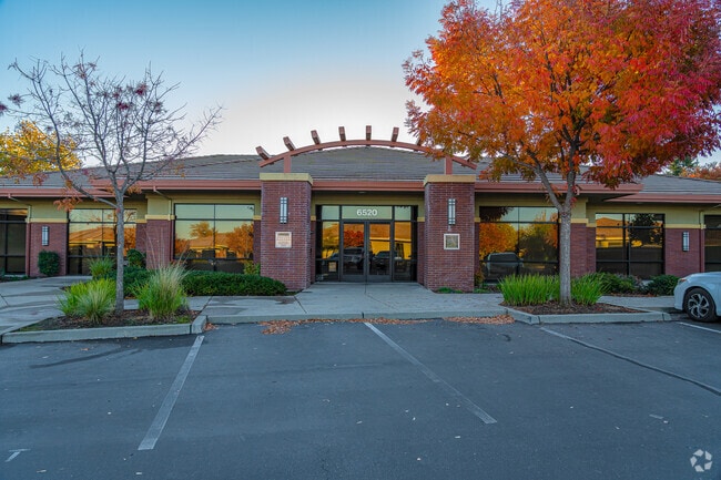 Fall colors surround the red brick building of Peak Prep Pleasant Valley.