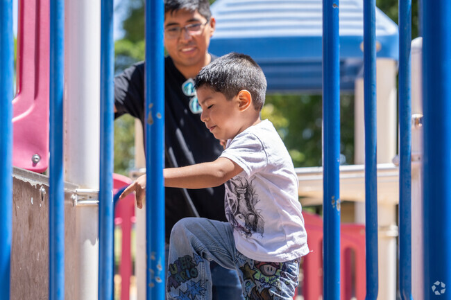 A father watches with pure adoration as his son takes on the play structure in Rose Glen.