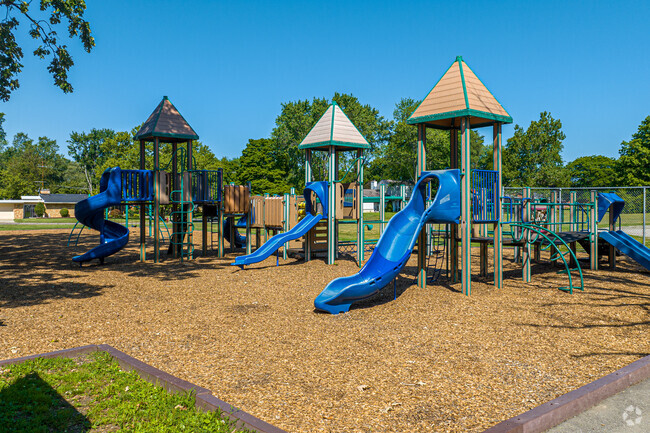 Playground has huts on top for kids to get shaded cover on the jungle gym.