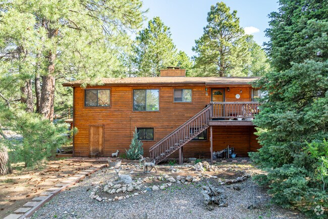 A well-designed log cabin sits on a wooded lot in Bow and Arrow Acres, Flagstaff.