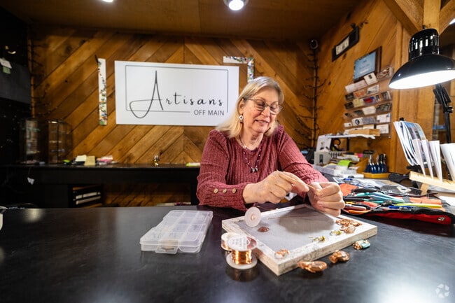 Artist Terri Cheatham creates new jewelry while manning the store, Artisans Off Main.