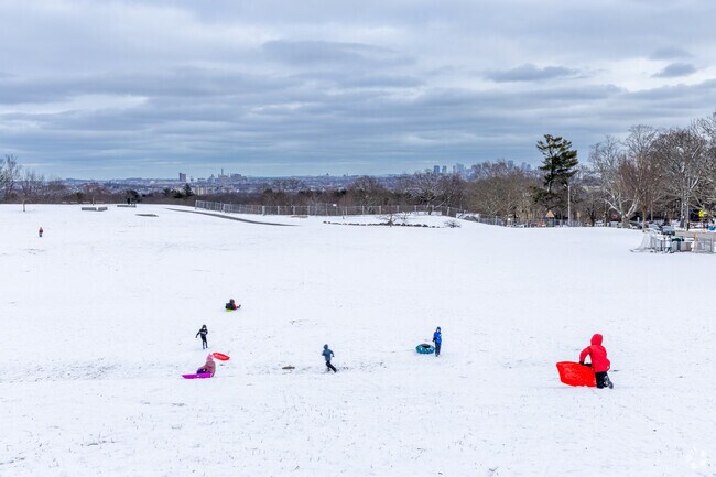 A group of children play at Robbins Farm Park with it's amazing view overlooking Boston.