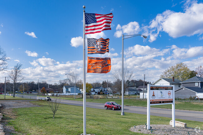 An American flag shares the pole with the local team's flags in West Park-Columbia.