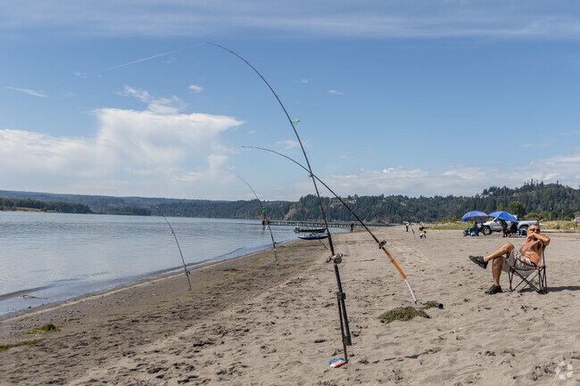 A fisherman enjoys a sunny day on the banks of the Columbia River.
