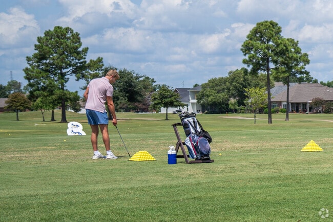 A golfer practices iron shots at the driving range at Graywood.