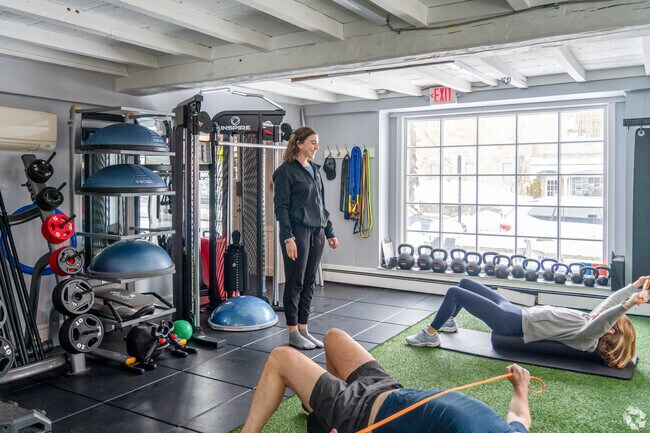 A personal trainer at Intuitive Wellness in Weston guides people in a private training session.