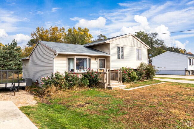 Split-level home in Evansdale sits among mature trees and greenery.