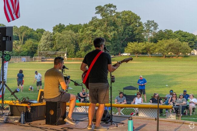 Residents gather to watch the live music in the park at Denville Music in the Park.