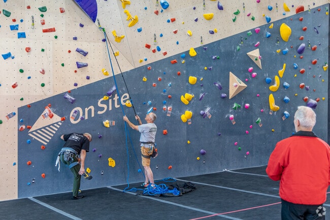 An Ascend employee works on changing the climbing wall grips in Point Breeze North.