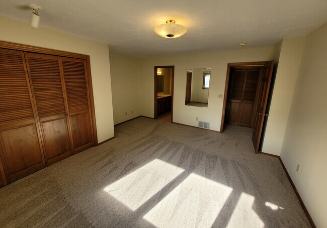 Large master bedroom. Closet on left, bathroom center, door to hallway on right.