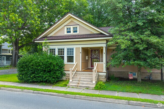 Towering trees and full-bodied shrubs define this serene front lawn in Wyoming, DE.