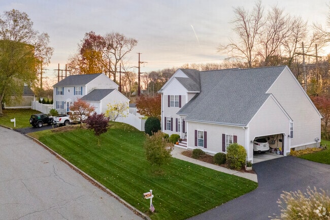 Rows of neat homes sit quietly on Natick streets as the sun sets.