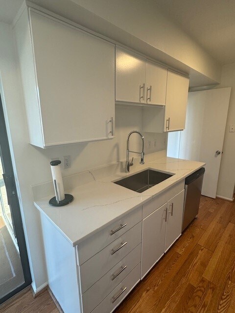 Renovated kitchen with granite counter, stainless steel appliances, large square sink and industrial