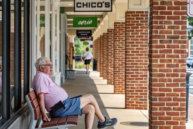 Residents relax in the shade at Barracks Road Shopping Center just outside of Rose Hill.