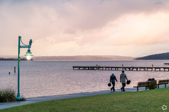 A couple walks the coastline at Doris Cooper Houghton Park in Downtown Kirkland.