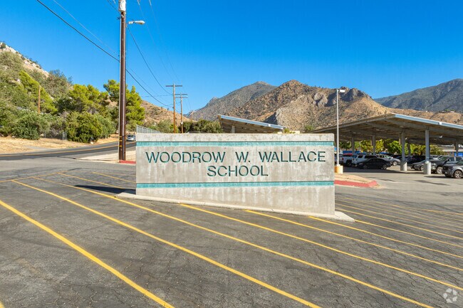 A large concrete sign welcomes students to Woodrow W. Wallace Elementary School.