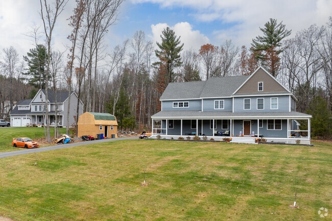 This modern colonial home with a wide front porch sits on a generous yard, offering plenty of outdoor space.