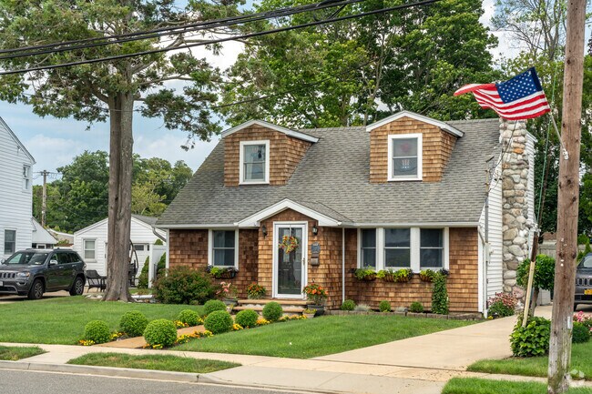 Dormered cape style home with it's patriotism on display.