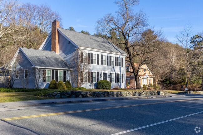A group of homes including a historic Colonial home along the roadway in Weston, MA.
