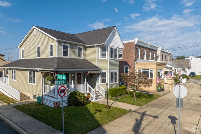 A newer Victorian-style home accompanies brick duplexes on this Marcus Hook street.