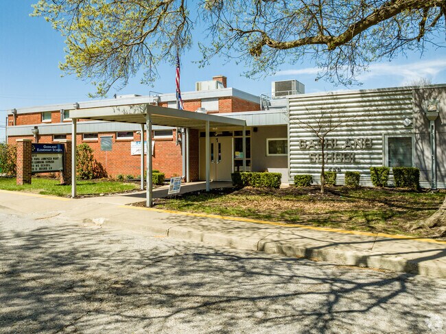 The entrance to Gashland Elementary School is shaded by the trees surrounding the building.