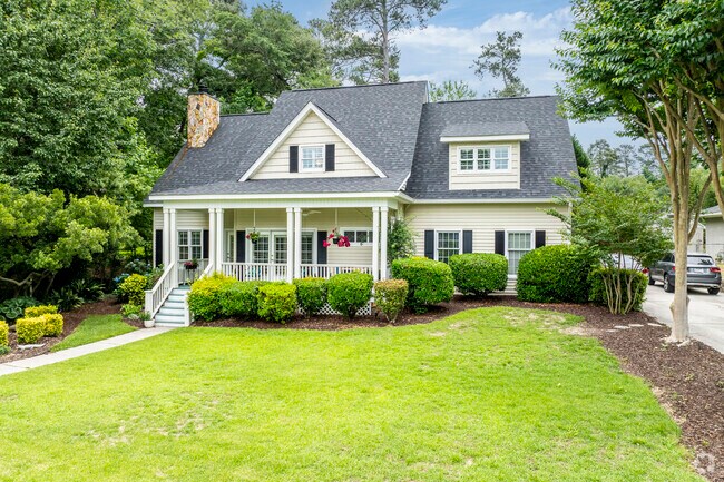 This Cottage-style home is surrounded by lush vegetation.